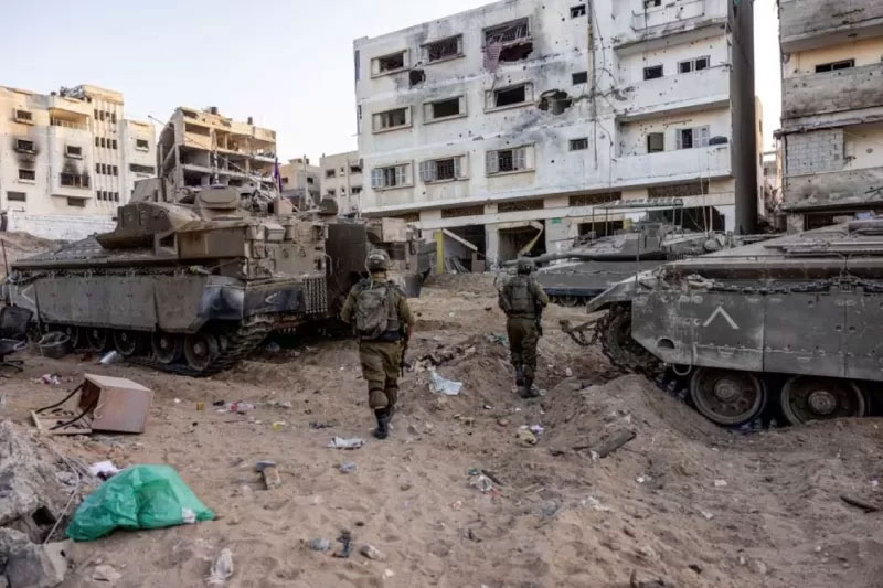 Tentara Israel berjalan melewati reruntuhan, di tengah invasi darat yang sedang berlangsung terhadap kelompok Islam Palestina Hamas di Jalur Gaza utara, 8 November 2023.