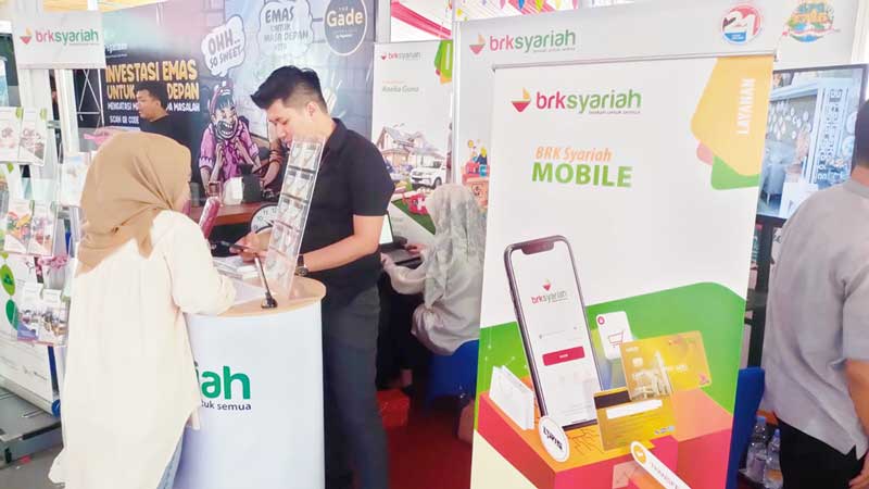 Pegawai Bank Riau Kepri Syariah melayani masyarakat yang menggunakan QRIS sebagai aplikasi untuk pembayaran.