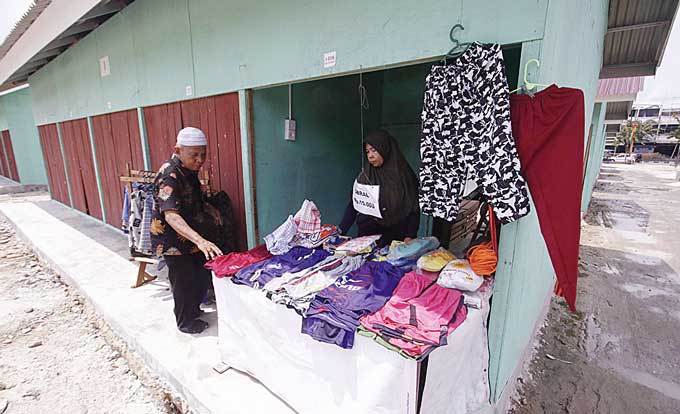 Pedagang Pasar Cik Puan Ramani dan Sidi Bujang sudah mulai menempati dan berjualan di kios TPS, Selasa (2/5/2023). Meski sudah dimenerima kunci, masih banyak pedagang yang belum pindah.