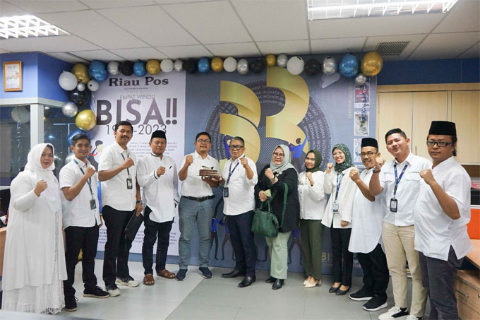 Direktur Utama Riau Pos Ahmad Dardiri (lima kiri) didampingi Direktur Riau Pos Asmawi Ibrahim (tiga kanan) dan Firman Agus (kanan) dan direksi Riau Pos menerima kue tar dariÂ  PT Pegadaian Kanwil II Pekanbaru yang diserahkan Deputi Bisnis PT Pegadaian are