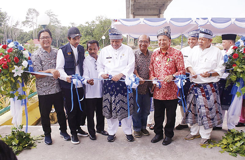 Bupati Siak Alfedri menggunting pita tanda diresmikan pemakaian lift Jembatan TASL Siak, disaksikan Direktur Utama Riau Pos Ahmad Dardiri (kiri), Kadis PU Tarukim Irving Kahar, Kadis Pariwisata Tekad Perbatas, dan tamu dari Malaysia Ramzi, Kamis (12/10/20