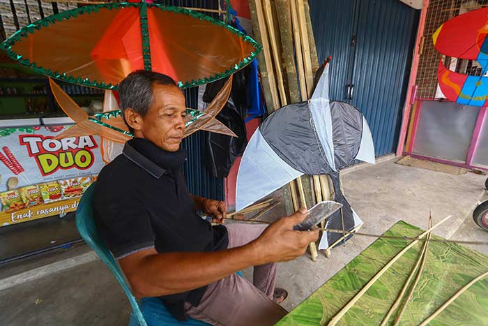 Buat Layang-Layang: Pembuat Layang-layang Syafruddin meraut bambu di depan tempat usahanya di Jalan Budi Luhur Pekanbaru,  Rabu (1/7/2020). Layang-layang menjadi salah satu mainan tradisional yang banyak dijumpai saat ini di sejumlah pelosok kota.  EVAN G