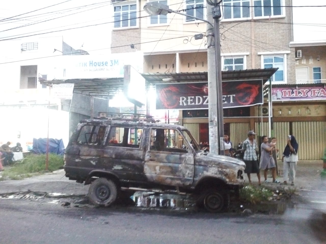 Satu unit mobil MPV milik Lano (63) yang terbakar di Jalan Delima, Pekanabru, Jumat (24/1/2020). (SOFIAH/RIAUPOS.CO)