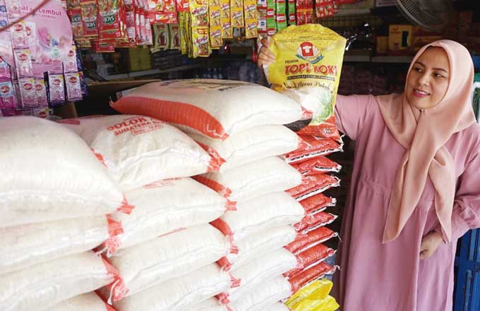 Mia, pedagang memperlihatkan tumpukan beras yang dijual di kios miliknya di Pasar Dupa, Pekanbaru, Selasa (2/5/2023).