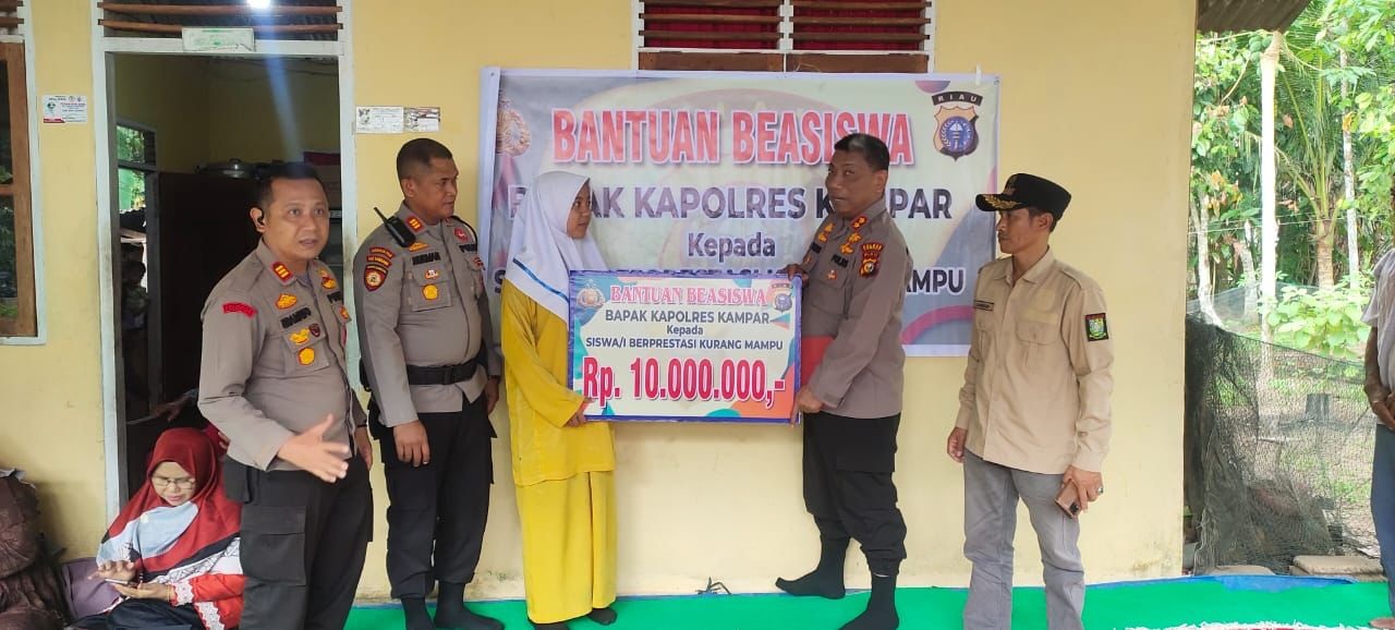 Kapolres Kampar AKBP Didik Priyo Sambodo menyerahkan bantuan beasiswa kepada siswa penerima saat berkunjung ke Desa Bukit Kemuning, Kampar, Jumat (10/3/2023).