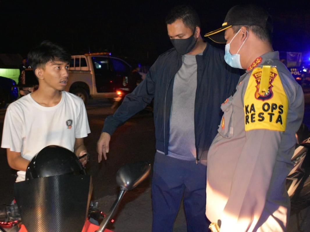 Kapolresta Pekanbaru Kombespol Nandang Mu&rsquo;min Wijaya saat menegur masyarakat yang tidak menggunakan masker pada patroli hunting PSBB, Jumat (8/5/2020) malam.(Polresta Pekanbaru for RIAUPOS.CO)