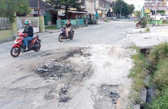 Kendaraan bermotor melintas dijalan yang rusak, dijalan Melur ujung, Pekanbaru. Selasa (12/10/2021). Jalan rusak karena bekas galian PDAM dan juga dilewati oleh alat berat