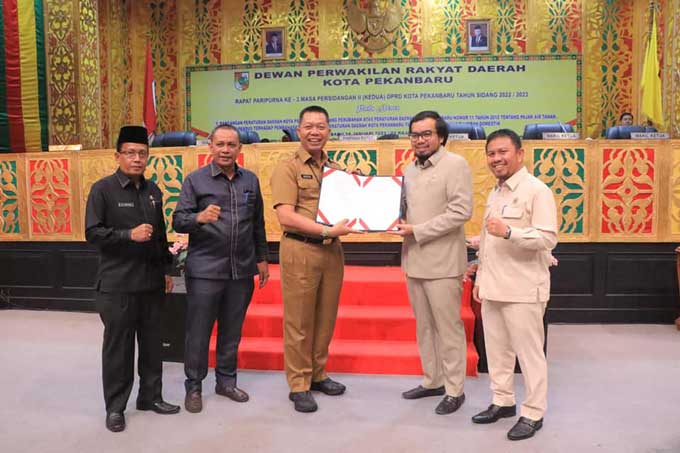 Wakil Ketua DPRD Pekanbaru Ginda Burnama (dua kanan) bersama Pj Sekko Pekanbaru Indra Pomi (tengah) menunjukkan berkas perda yang sudah disahkan dalam rapat paripurna didampingi Ketua Pansus Nurul Ikhsan (kanan), Ketua Bapemperda DPRD Pekanbaru Zulfahmi (