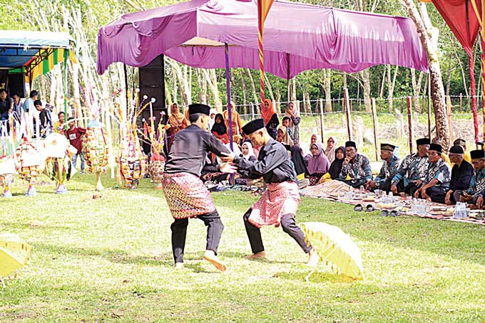 Aksi pencak silat salah satu acara yang digelar dalam acara doa padang, yang dilaksanakan masyarakat Banjar Nan Tigo Desa Nan Ompek, Kecamatan Kuantan Hilir, Kamis (9/2/2023).