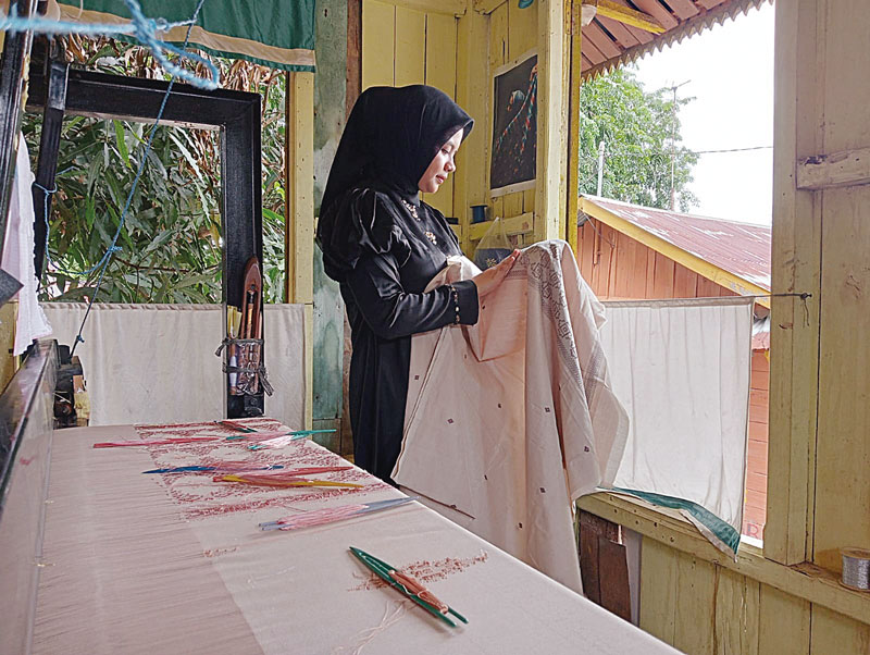 Desainer muda Pekanbaru Thiffa Qaisty Salsabila melihat langsung kain tenun yang akan dibawa ke Front Row Paris 2023 di Rumah Tenun Kampung Bandar, Rabu (30/8/2023).