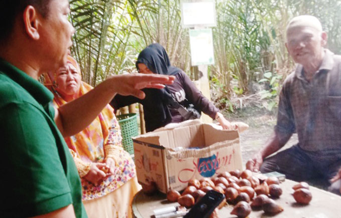 Ketua DPRD Siak Indra Gunawan berbincang dengan Mukadi warga Banjar Seminai, Dayun, didampingi Penghulu Siti Aminah pada Ahad (21/5/2023).