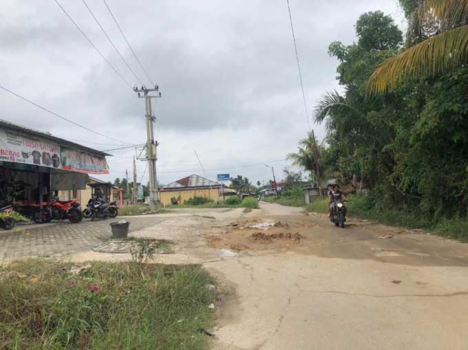 Pengendara melintas di Jalan HM Nur, Kecamatan Rumbai Timur yang mengalami kerusakan cukup parah, Rabu (4/8/2021). Jalan rusak ini sudah berlangsung selama kurang lebih dua tahun dan belum ada upaya perbaikan.