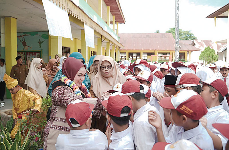 Bunda PAUD Rohil Sanimar disalami para siswa saat berkunjung di SDN 001 Bagan Kota di Bagansiapiapi, baru-baru ini.