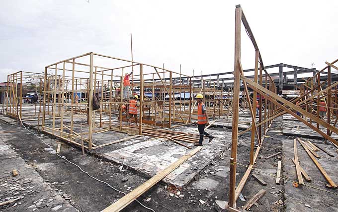 Para pekerja melakukan pembangunan Tempat Penampungan Sementara (TPS) pedagang di Pasar Cik Puan, Jalan Tuanku Tambusai, Pekanbaru, Rabu (15/3/2023). Pembangunan ini ditargetkan selesai dalam dua pekan pengerjaan.
