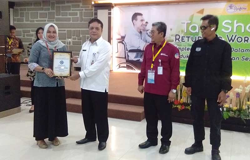 SERAHKAN PIAGAM:Â Direktur Rumah Sakit Syafira Rina Elviani (kiri) menyerahkan piagam penghargaan kepadaÂ Kadis Ketenagakerjaan dan Transmigrasi Provinsi Riau H Rasidin SH (dua kiri) dalam talk showÂ Return To Work (RTW), Rabu (10/4/2019). (PRAPTI DWI LES