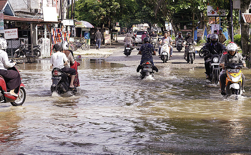 Pengendara melewati genangan air di Jalan Cipta Karya, Kecamatan Tuah Madani, Kamis (23/11/2023). Hujan deras mengguyur sebagian wilayah Kota Pekanbaru pada Rabu (22/11/2023) malam.