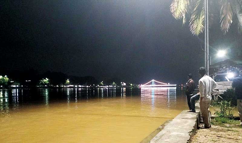 Sebagian daerah di Kabupaten Kuantan Singingi mulai terendam banjir. Tampak air mulai mencapai jembatan gantung Telukkuantan, Senin (18/12/2023) malam.