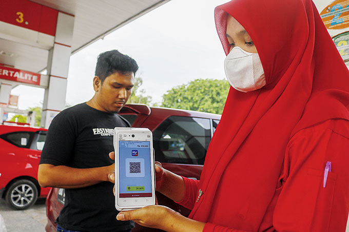 Petugas SPBU memperlihatkan QR Code di aplikasi MyPertamina sebelum melakukan pengisian BBM subsidi di salah satu SPBU di Jalan Arifin Achmad Pekanbaru, Ahad (11/9/2022).