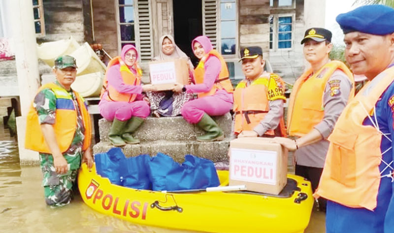 Kapolres Pelalawan AKBP Suwonto SH SIK menyerahkan bantuan kepada warga Dusun Muara Sako, Kelurahan Langgam, Kecamatan Langgam yang terdampak banjir Sungai Kampar, Selasa (12/12/2023).