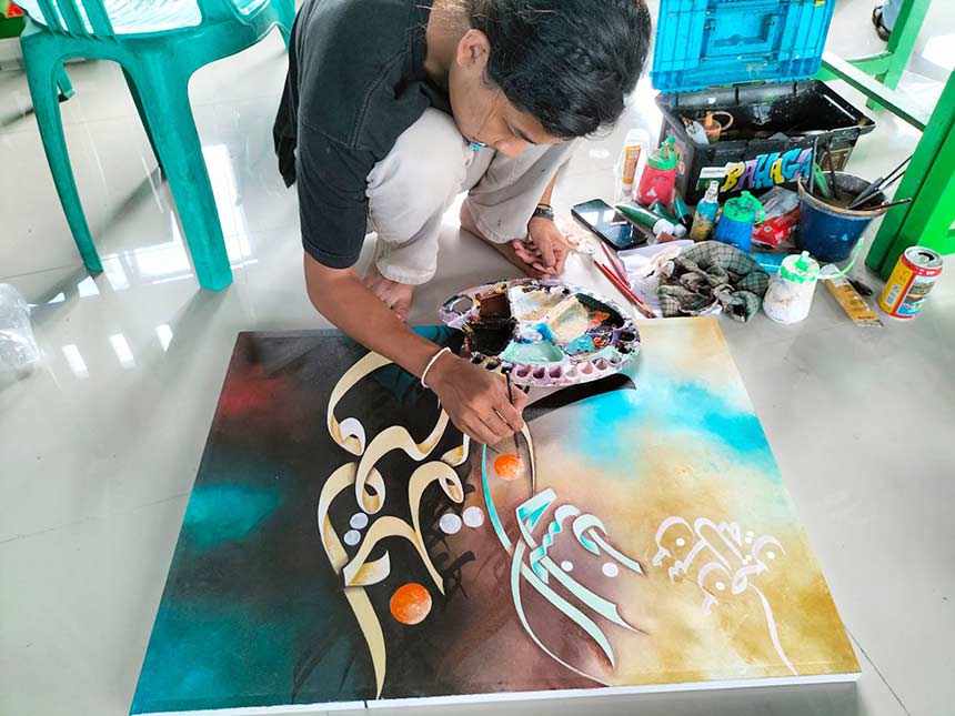 Seorang siswa Sanggar Kaligrafi Al-Fath, Kampung Tanjung Kuras, Kecamatan Sungai Apit, Siak, sedang menyelesaikan salah satu lukisannya, baru-baru ini.