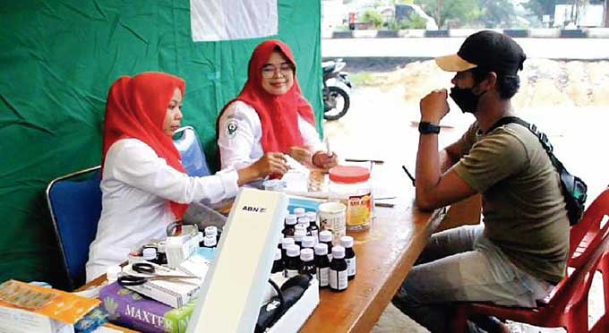Petugas medis melakukan pemeriksaan kesehatan terhadap salah seorang warga yang mengungsi di posko karena dampak banjir di Kecamatan Batu Hampar, Kabupaten Rohil, baru-baru ini.