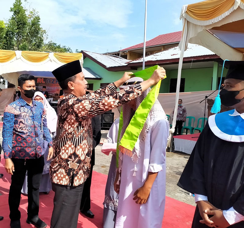 Staf Ahli Bupati Bidang Pemerintahan, Hukum dan Politik, Toharuddin memasang shal kepada peserta wisuda akbar Ponpes Darunnajah dan Panti Asuhan Al-Ghasyiyah, di Kecamatan Bathin Solapan, Kamis (17/3/2022).
