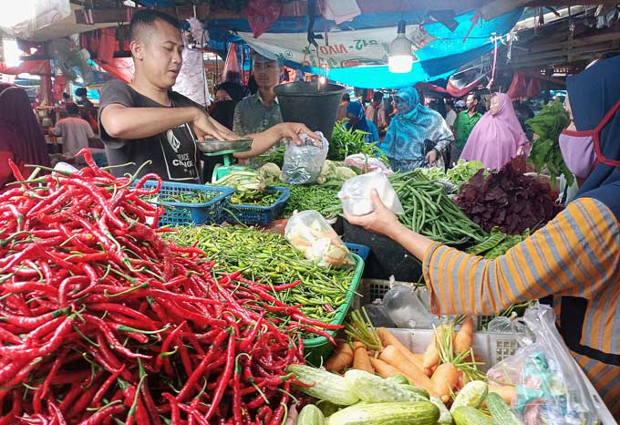 Aktivitas jual beli antara pedagang dan pembeli di Pasar Pagi Simpang Baru Panam, Kamis  (15/12/2022). Jelang Natal 2022 dan Tahun Baru 2023, harga barang sembako masih stabil.