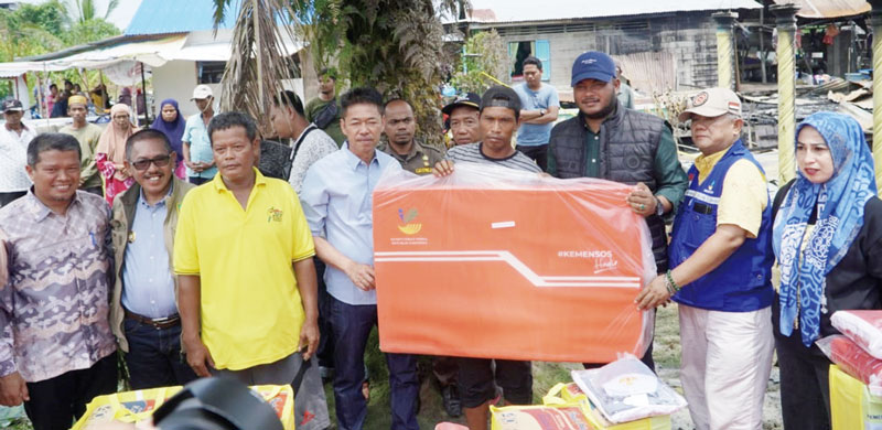 Bupati Rohil Afrizal Sintong SIP MSi didampingi Camat Bangko Aspri Mulya MSi menyerahkan bantuan bagi warga korban kebakaran di Bagansiapiapi, Sabtu (4/11/2023).