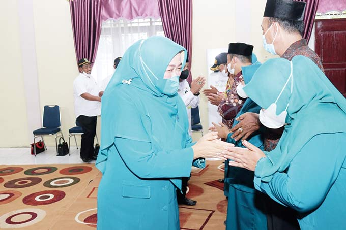 Rasidah Alfedri bersalaman sambil memberikan ucapan selamat kepada pengurus TP-PKK kampung usai dilantik di aula Kantor Camat Bungaraya, Rabu (9/2/2022).
