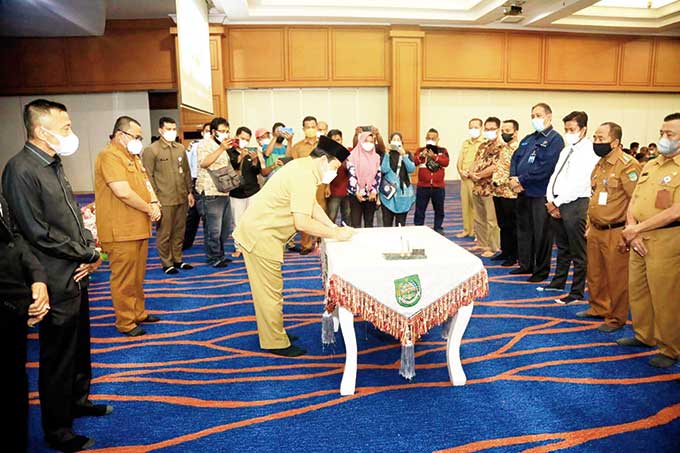 Bupati Rokan Hulu H Sukiman menandatangani berita acara Musrenbang Kabupaten Rohul tahun 2022 di Convention Hall Islamic Center Rohul, Selasa (29/3/2022). Foto kanan, Bupati Rokan Hulu Sukiman memberi sambutan sekaligus membuka Musrenbang secara resmi.