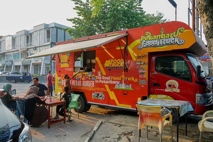 Pengunjung menikmati hidangan di food truck yang mangkal di kawasan Jalan Arifin Achmad, Pekanbaru, Sabtu (29/1/2022).