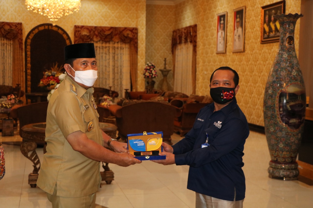 Branch Manager Taspen Kantor Cabang Pekanbaru, Muhammad Isya menyerahkan plakat kepada Bupati Rokan Hulu, H Sukiman, Jumat di kediaman bupati di Pasirpangaraian.(12/09/2020)