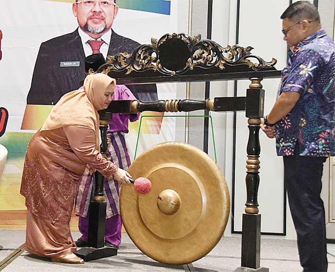 Bupati Bengkalis Kasmarni  memukul gong saat meluncurkan  Program Sanitasi Bermasa sekaligus membuka Rakor Kelompok Kerja Pengembangan Perumahan dan Kawasan Permukiman Kabupaten Bengkalis di  Pekanbaru, Jumat (16/9/2022).