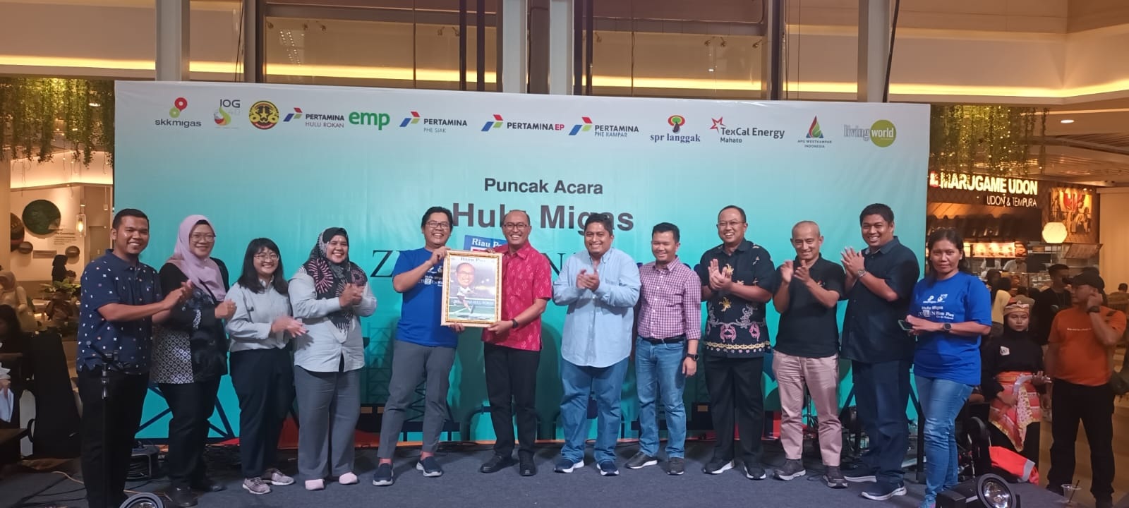Direktur Utama Riau Pos Ahmad Dardiri serahkan cendramata kepada Corporate Secretary PHR Rudi Ariffianto pada pembukaan iven puncak Hulu Migas Zetizen Riau Pos Goes to School 2023 di Living World, Sabtu (4/11/2023).