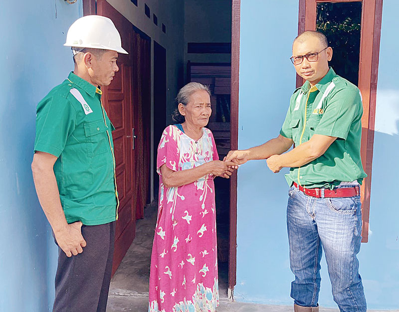 Manager Mill PT MAN M Syahid Syar (kanan) didampingi KTU PT MAN Parhimpunan Hasibuan menyerahkan kunci rumah layak huni yang dibangun  PT MAN melalui program TJSP kepada Sakinem, warga Desa Bangun Jaya, Kecamatan Tambusai Utara, Rabu (8/11/2023).