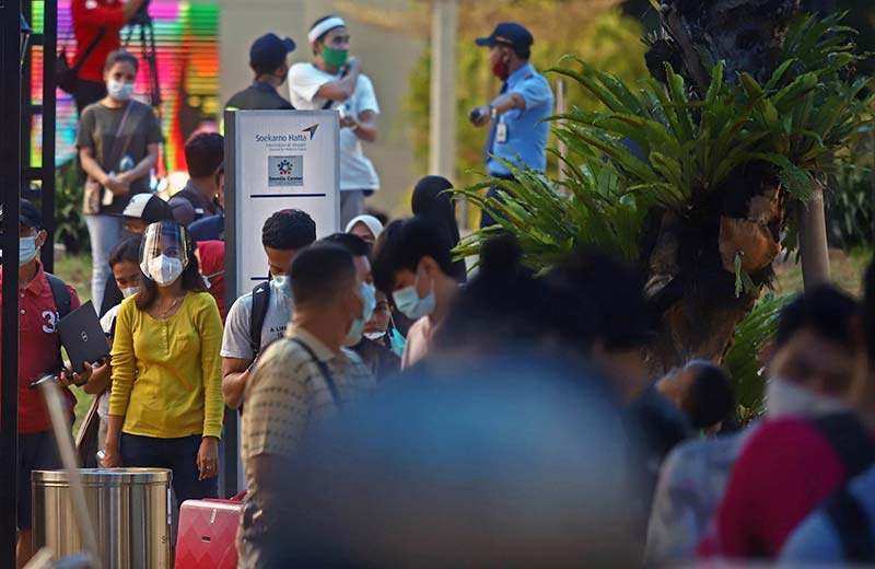 Para calon penumpang memadati tempat tes rapid dan PCR di Terminal 3 Bandara Soekarno-Hatta, Tangerang, Jumat (18/12/2020). Calon penumpang pesawat sebelum keberangkatan harus menunjukkan surat hasil PCR test atau rapid antibodi berlaku untuk 14 hari sete