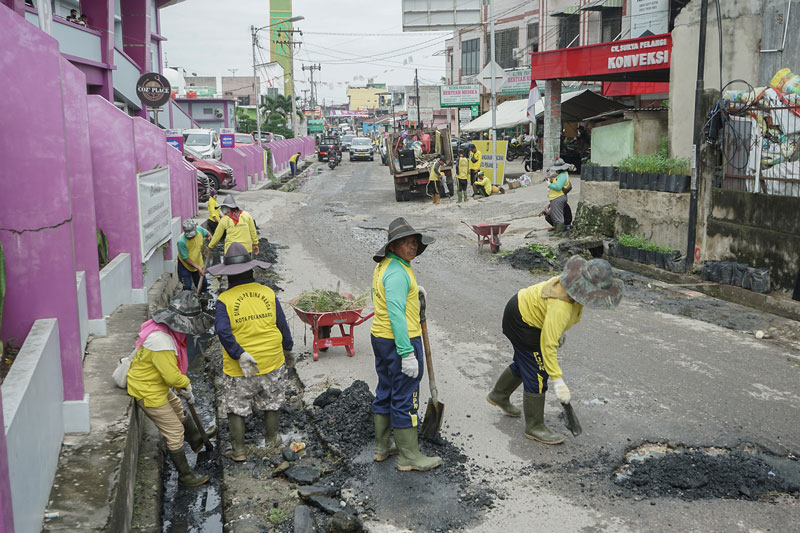 Pekerja Sumber Daya Air Dinas PUPR Kota Pekanbaru membersihkan saluran air atau drainase di Jalan Puyuh Mas dalam penanganan banjir permukiman warga Pekanbaru, Kamis (7/9/2023).