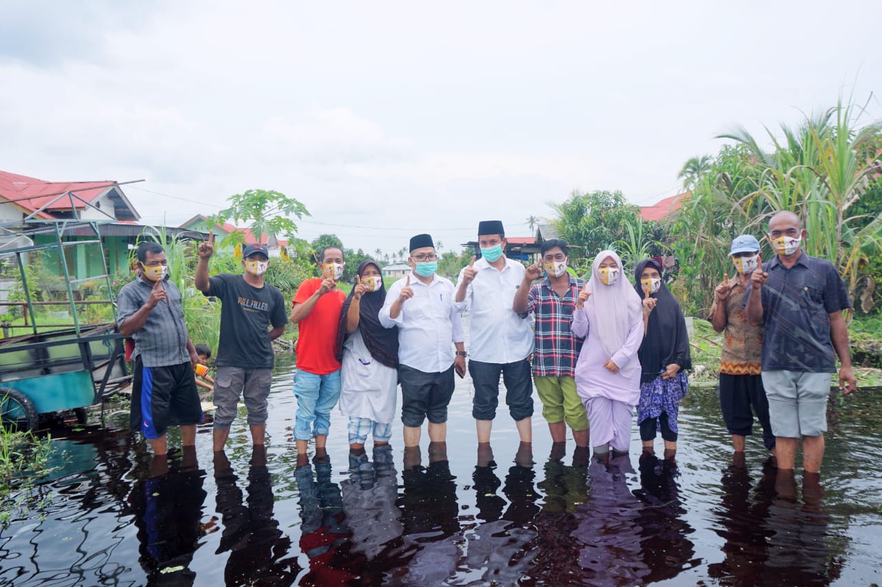 Paslon Cutra Andika-M Rafik (Camar) melihat kondisi banjir di sela kampanye tatap muka di Kecamatan Bangko, kemarin. (TIM PEMENANGAN CAMAR UNTUK RIAUPOS.CO)