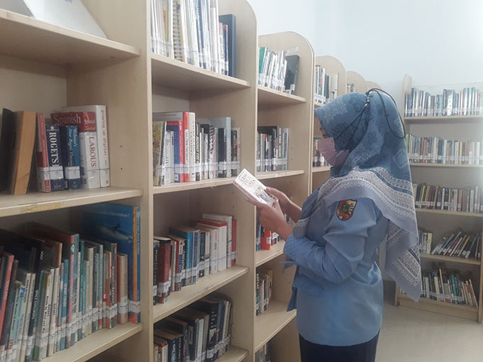 Pegawai Perpustakaan Tenas Effendy sedang melihat dan merapikan buku-buku koleksi perpustakaan, Rabu (26/10/2022).
