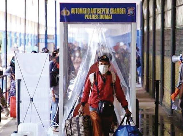 Pekerja Migren Indonesia dari Malaysia melewati alat automatic antiseptic chamber Polres Dumai sebagai upaya sterilisasi dari Covid-19 setibanya di Pelabuhan Domestik Bandar Sri Junjungan, foto diambil Maret 2020 lalu.