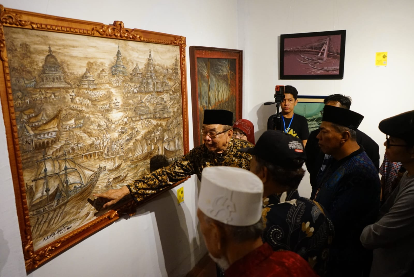 Seniman dan Budayawan Riau OK Nizami Jamil menunjuk lukisan Muara Takus Kuno karya Latief Hasyim pada malam pembukaan pameran seni rupa MasteRiau pada Sabtu (13/8/2023).