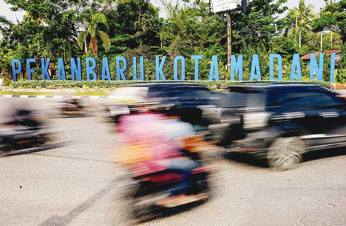 Kendaraan melintas di dekat tugu Pekanbaru Kota Madani, Jalan Jenderal Sudirman, Senin (2/1/2023).  Pemko Pekanbaru akan mengembalikan slogan Pekanbaru Kota Bertuah dan menghapus kata Madani.