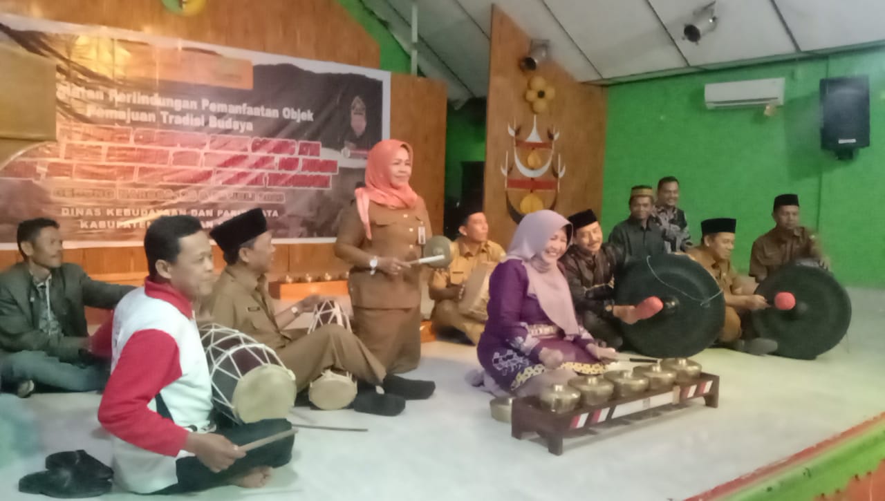 Teks: Ketua Umum Dewan Kesenian Kuantan Singingi Hj Yulia Suhardiman bersama Kepala Disbudpar Kuansing Drs Azhar MM memainkan musik Rarak Godang saat membuka pelatihan, di Gedung Narosa Teluk Kuantan, Senin (24/7/2023).