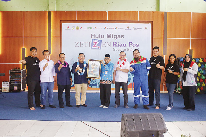 Kepala SMAN 1 Pangkalankerinci H Adroni MPd mengangkat cendera mata saat acara Hulu Migas Zetizen Riau Pos Goes to School 2023 di SMAN 1 Pangkalankerinci, Kamis (19/10/2023).