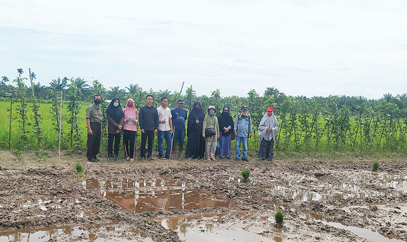Tim Pengabdian, petani, PPL dan mahasiswa Kukerta foto bersama di lahan sawah, lokasi rencana demplot dilakukan beberapa waktu lalu.(KKN UNRI FOR RIAUPOS.CO)