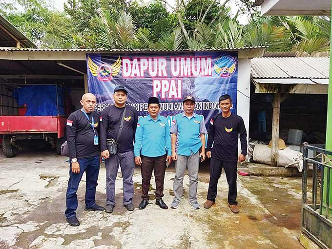 Anggota Persaudaraan Pengemudi Ambulans Indonesia (PPAI) Riau berfoto di depan dapur umum di lokasi bencana Gunung Semeru, beberapa waktu lalu.