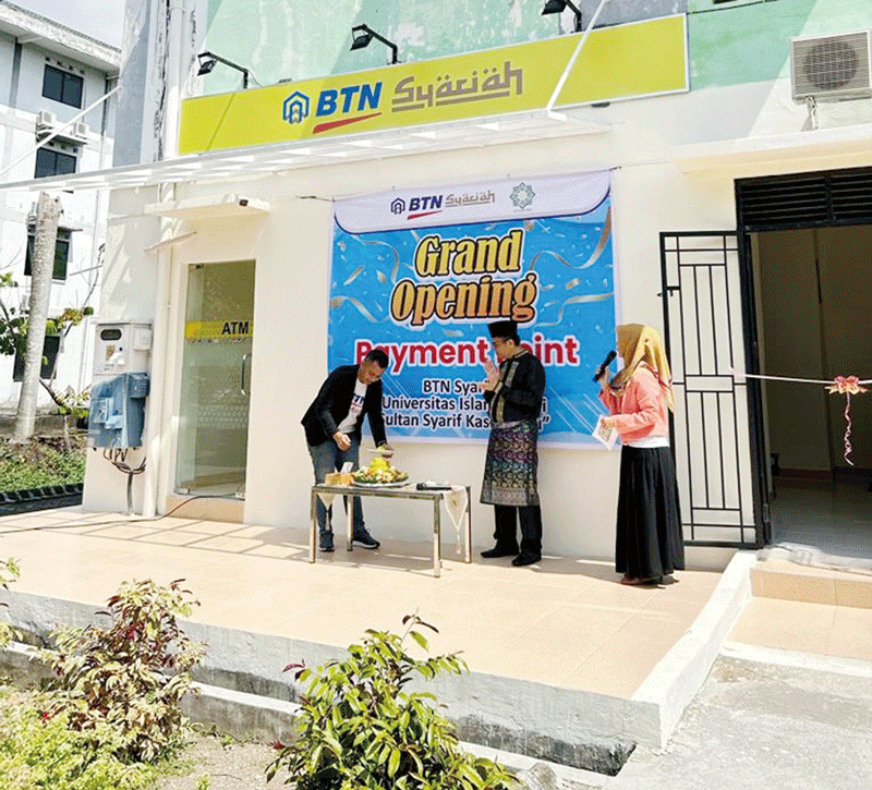 Pjs Branch Manager BTN Syariah Muhadi Eko Putra saat mengambil nasi tumpeng disaksikan Rektor UIN Suska Riau Prof Dr Khairunnas Rajab MAg pada Grand Opening Payment Point BTN Syariah UIN Suska Riau, Jumat (22/9/2023).