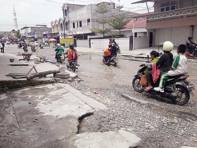 Genangan di badan Jalan Darma Bakti, Kecamatan Payung Sekaki menyulitkan pengendara untuk melintas, Jumat (13/1/2023).