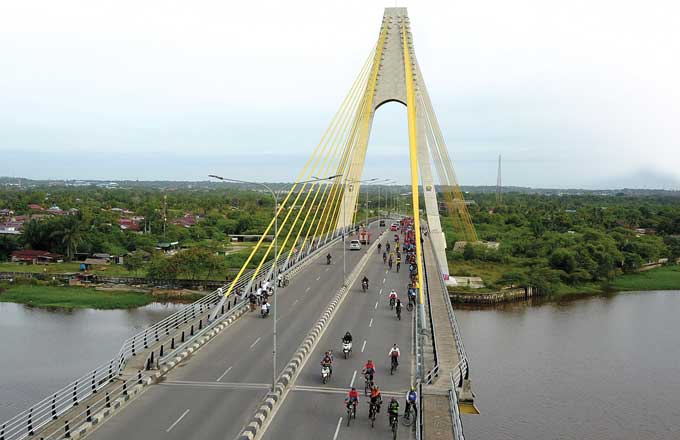 Para peserta melintas di Jembatan Sultan Abdul Jalil Alamuddin saat mengikuti Riau Pos Fun Bike, Ahad (29/1/2023).