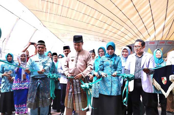 Pj Wako Pekanbaru Muflihun didampingi Ketua TP PKK Pekanbaru Raja Rilla Muflihun dan Sekdako Pekanbaru M Jamil MAg MSi memotong pita meresmikan Klinik Al-Muflihun, Rabu (3/8/2022).